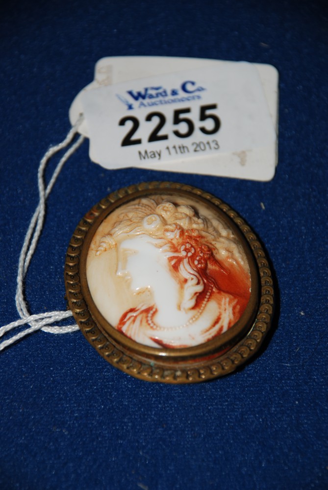 An Italian Cameo Brooch decorated with a classical lady with flowers in her hair in gold coloured