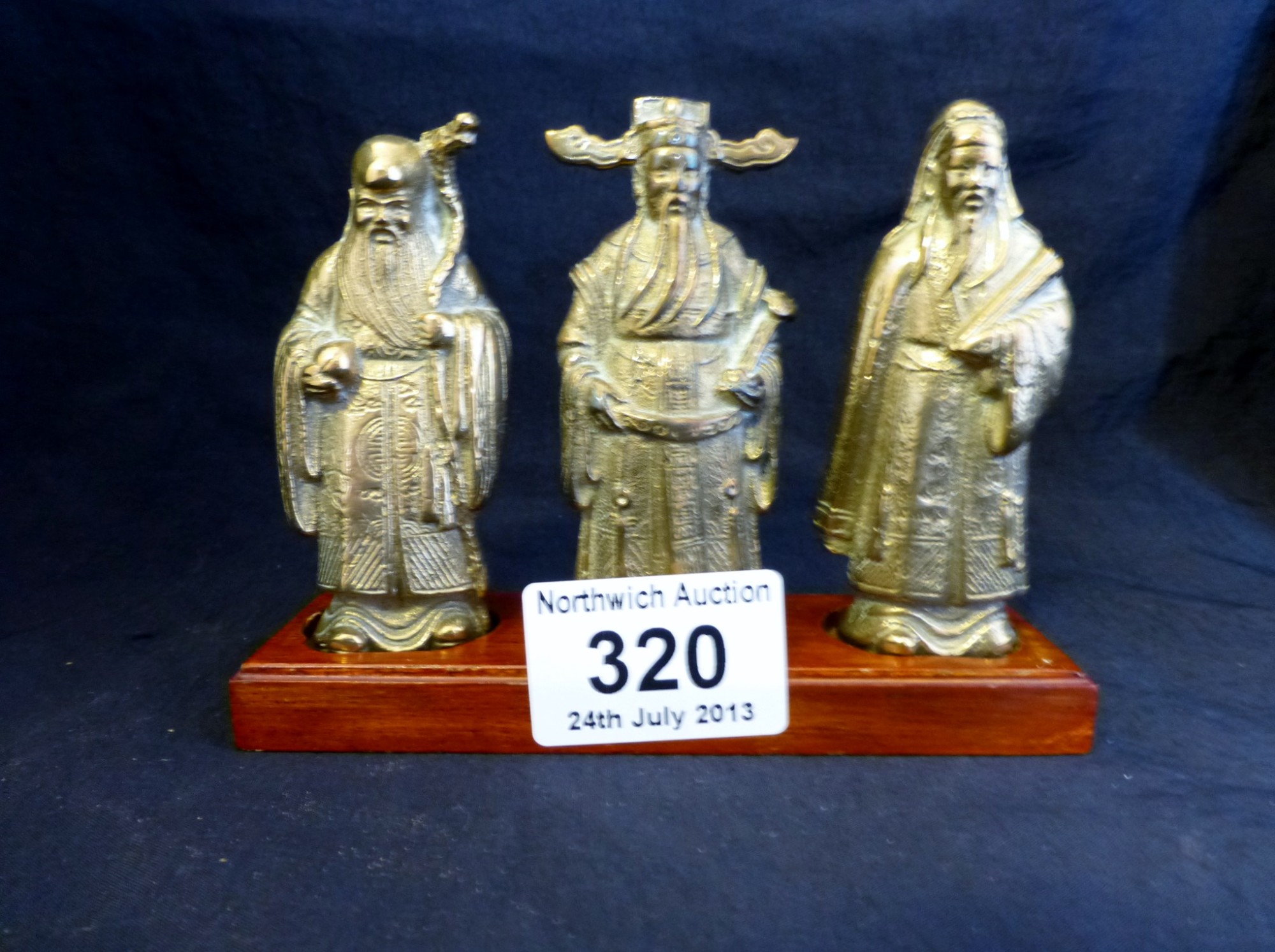 Three brass Chinese gods on hardwood base
