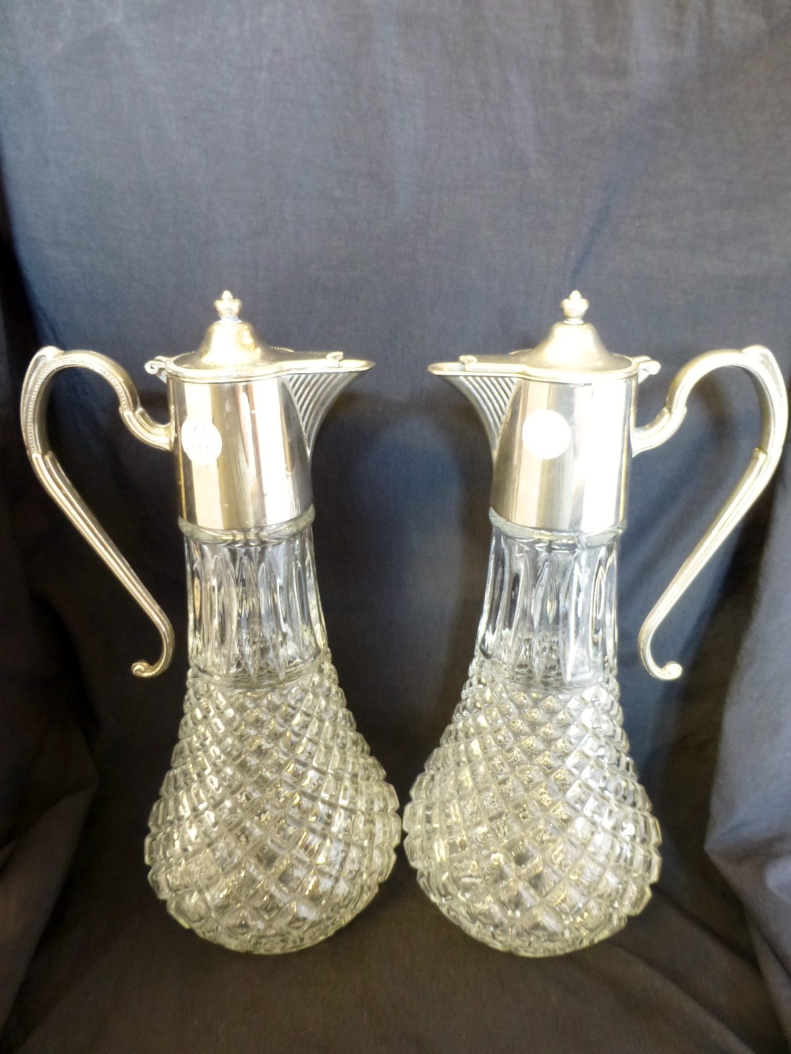 Pair of cut glass and silver plated claret jugs