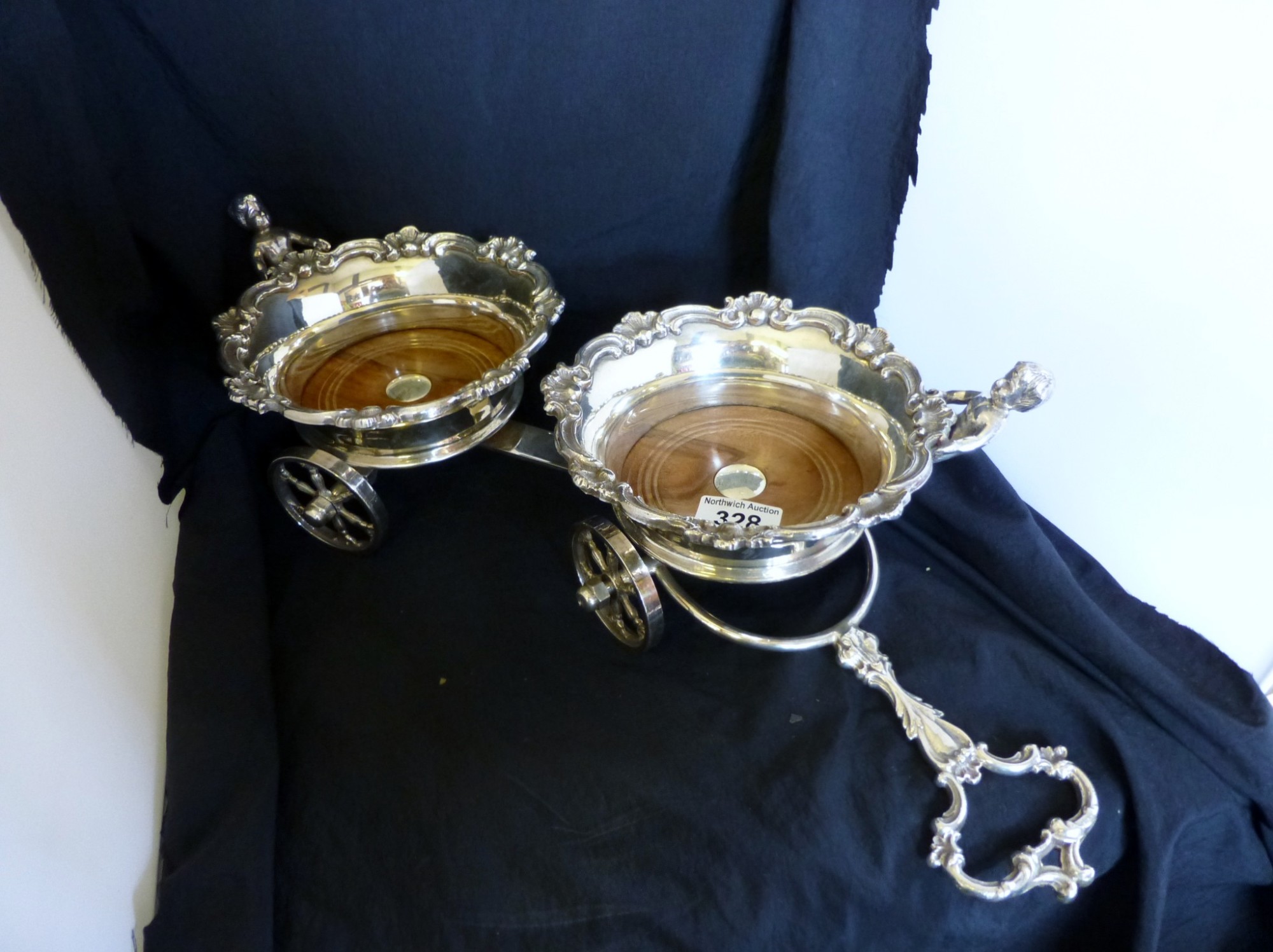 Silver plated double wine coaster table cart with scrollwork rim mounted with putti 53cm long