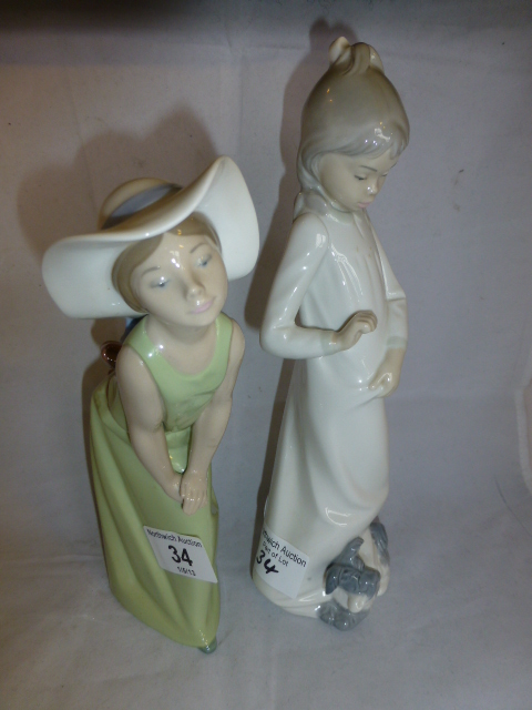 Lladro figurine of a girl wearing a hat and a Nao figurine of girl with a dog