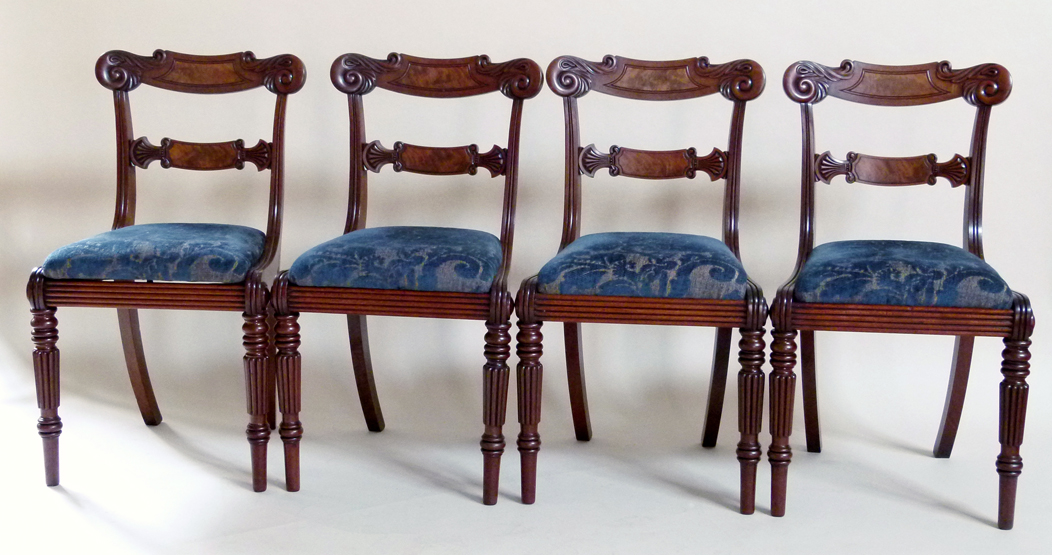 Four William IV mahogany dining chairs , each with a broad top rail and horizontal spar, on reeded