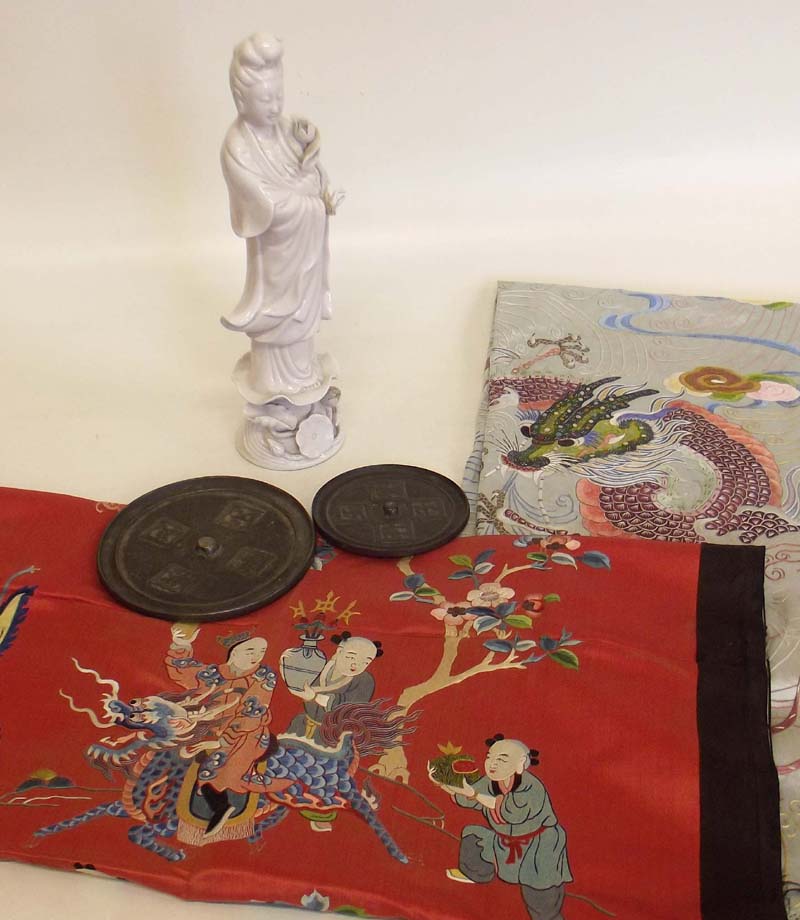 Chinese blanc de chine figure of Guanyin; two Chinese bronze mirrors and two Chinese embroidered