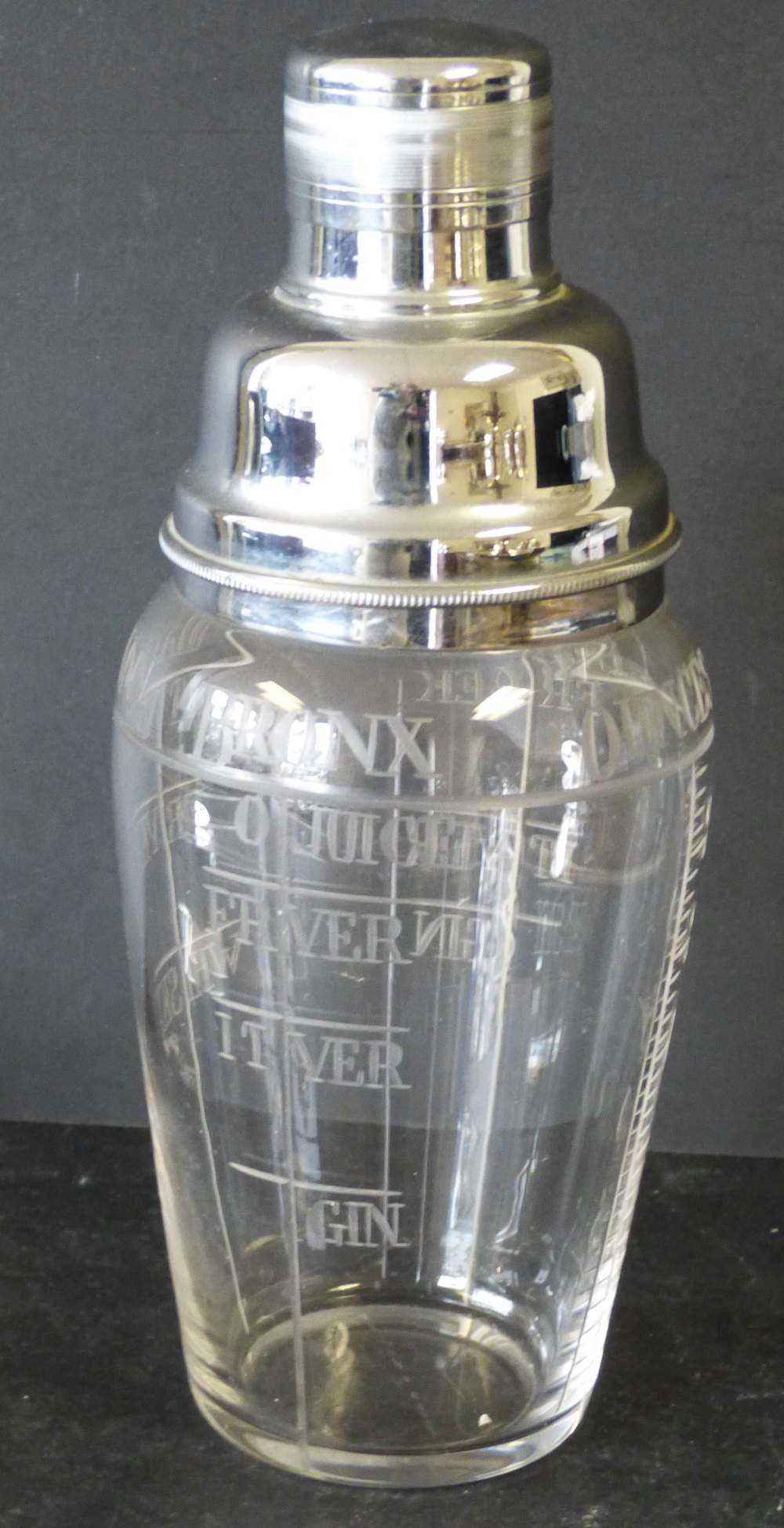 A Cut Glass Cocktail Shaker having plated cover, engraved `Martini, Manhattan, Bronx and Ounces`,