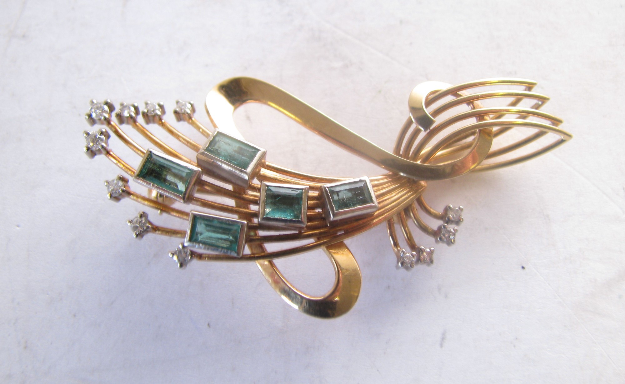 An 18ct Gold Art Deco Spray Brooch mounted with 5 green stones surrounded by 12 small diamonds, 9.