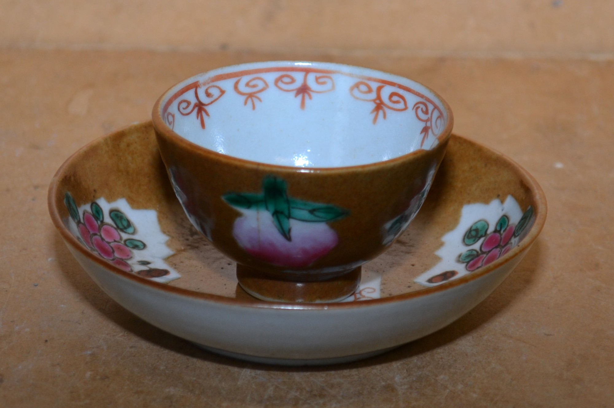 An 18th Century Tea Bowl on white and brown ground with multicoloured fruit and leaf decoration;