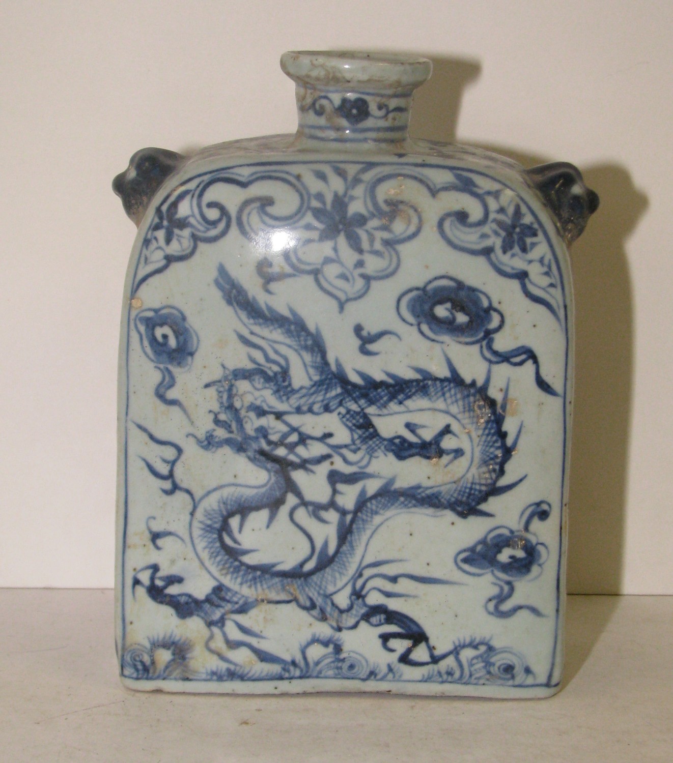 An Oriental Moon Flask on blue and white ground depicting dragons with dog of foe handles, 23cm high