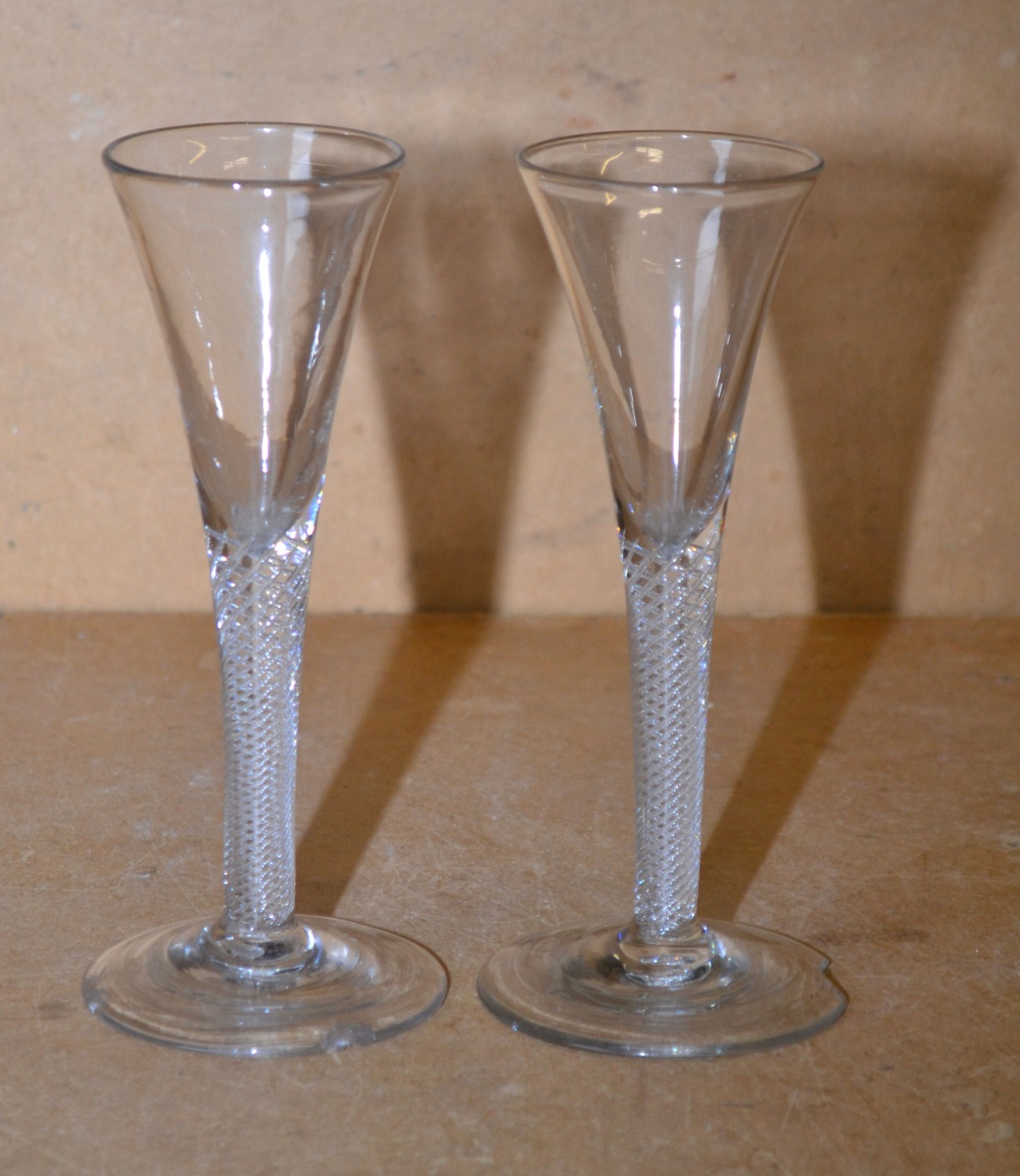 A Pair Round Trumpet Shaped Wine Glasses having inner twist stems on round bases (both bases