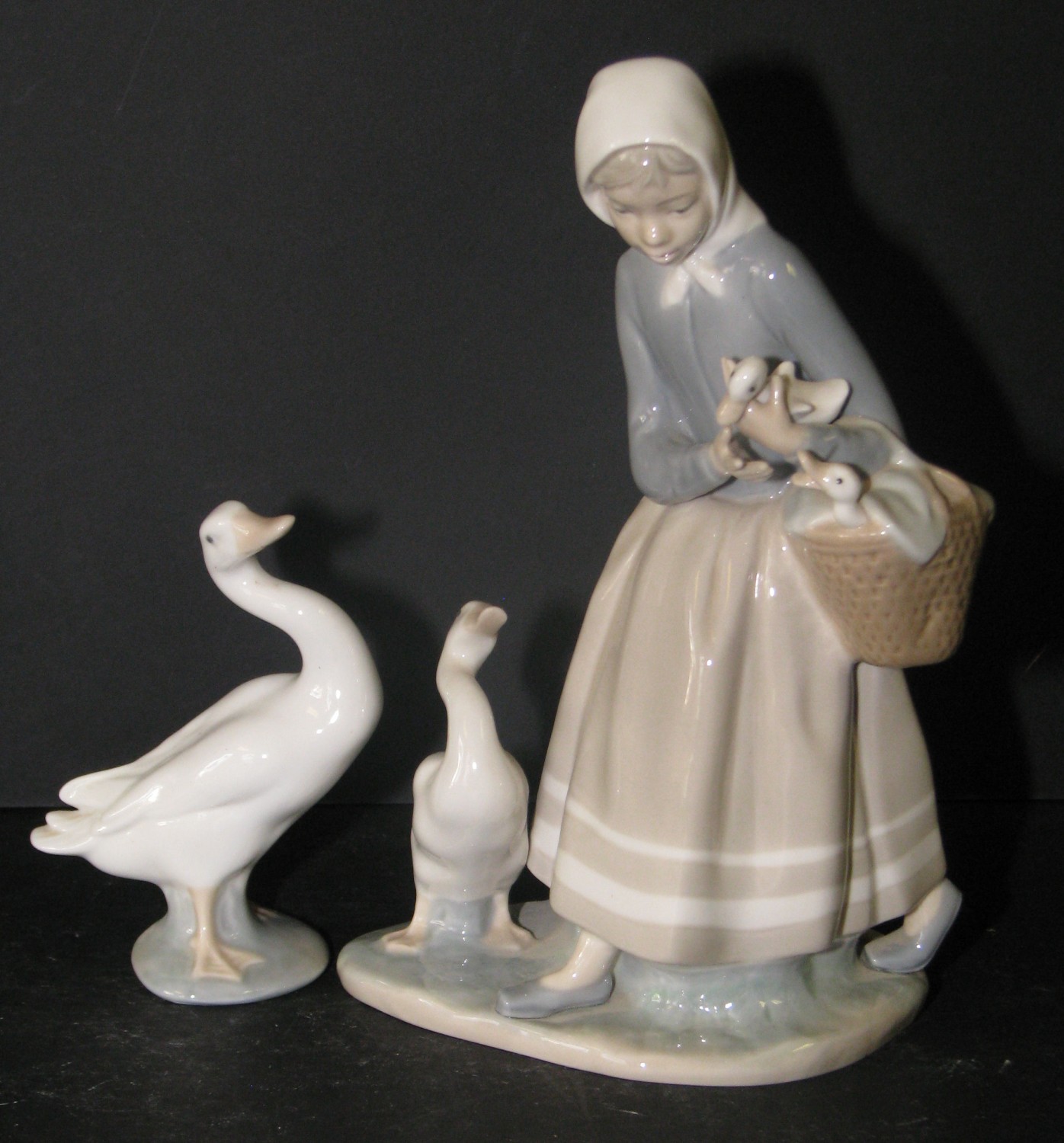 A Lladro Group of lady holding basket with duck at her feet; also another similar figure of a