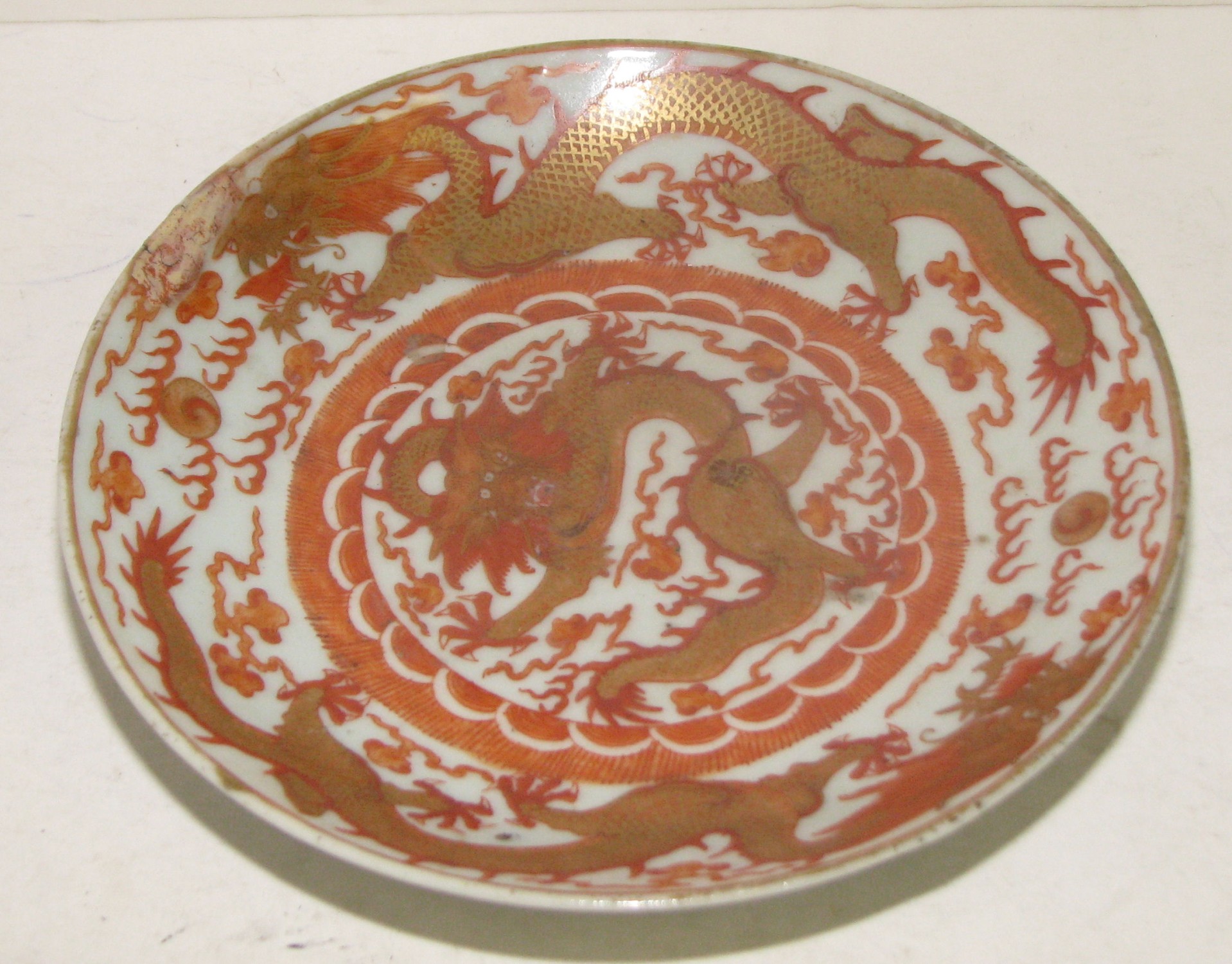 An Oriental Plate depicting red and gold dragons, 20cm diameter