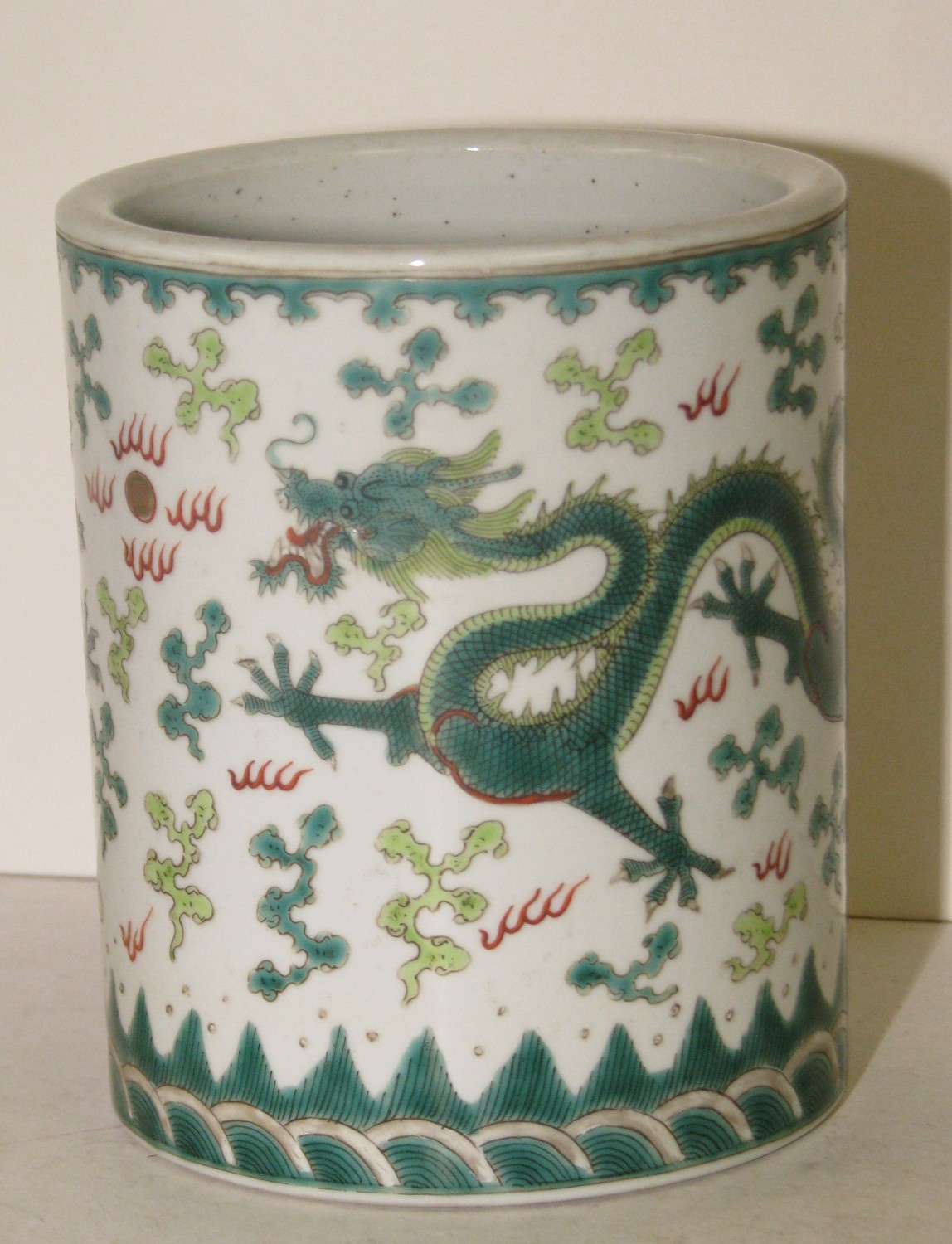 An Oriental Multicoloured Brush Pot depicting dragons chasing golden pearl, 15cm high