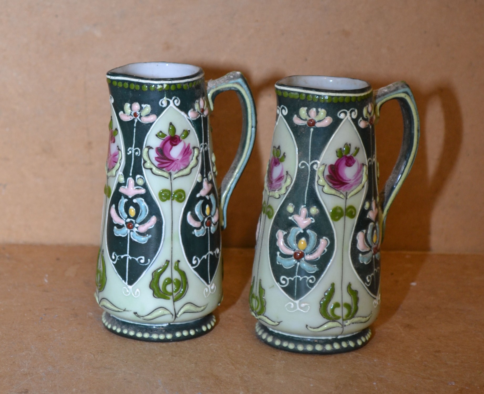A Pair China Small Jugs on light and dark green ground having multicoloured and raised rose,