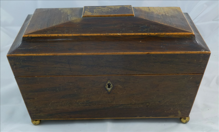 A Regency sarcophagus shaped tea caddy, the domed inlaid top opening to reveal two lidded caddy