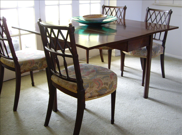 A Regency mahogany drop-leaf dining table, the rectangular top with plain frieze, raised on