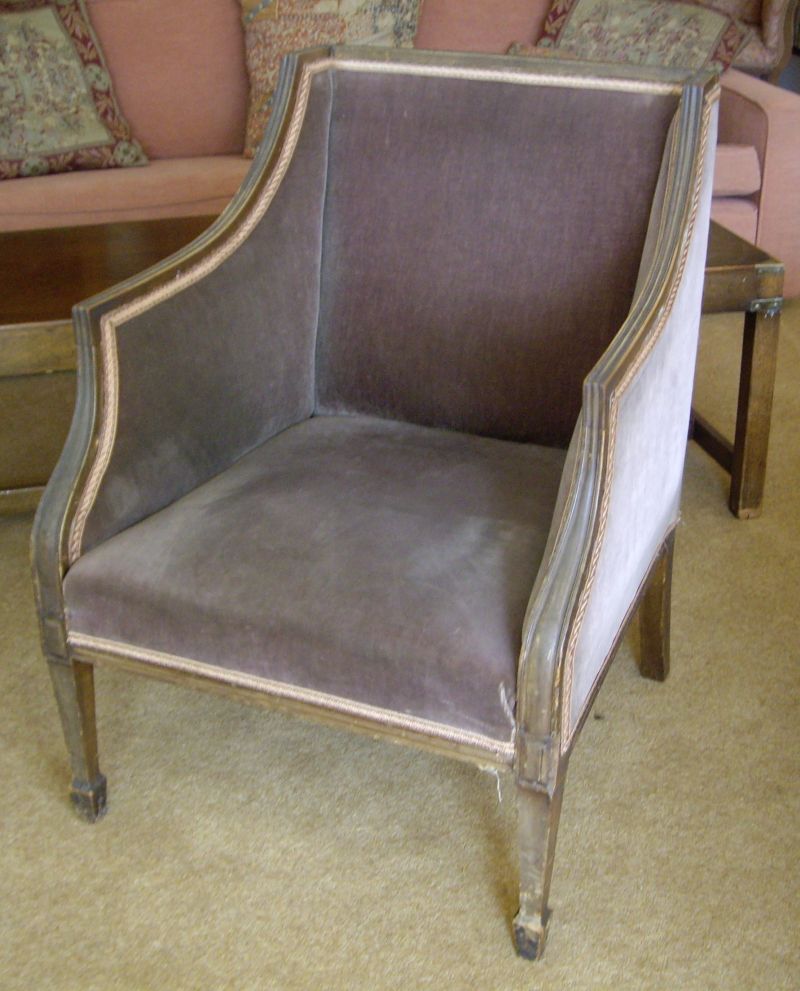 A Regency-style walnut armchair with moulded rail and scrolling arms, upholstered in a lilac