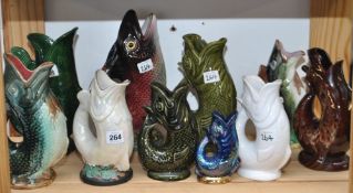 Collection of ten Dartmouth Pottery gurgling jugs, the tallest 29cm