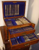 A canteen of silver plated cutlery housed in an oak cabinet with military recessed handles, 43cm