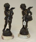 Pair of bronze figures of winged cherubs, one playing a drum another with a tambourine, on figured