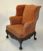 George II style armchair with upholstered wing back on carved claw ball feet with carved lower