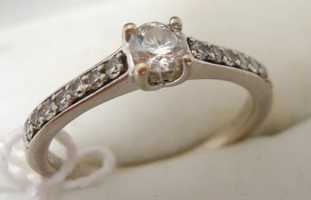 Modern 9ct white gold ring set with central diamond and 14 further diamonds to the shoulders,