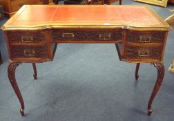 An early 20th century mahogany desk with red leather writing surface over three drawers with blind