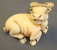 A carved ivory netsuke in the form of a cow, 30mm long