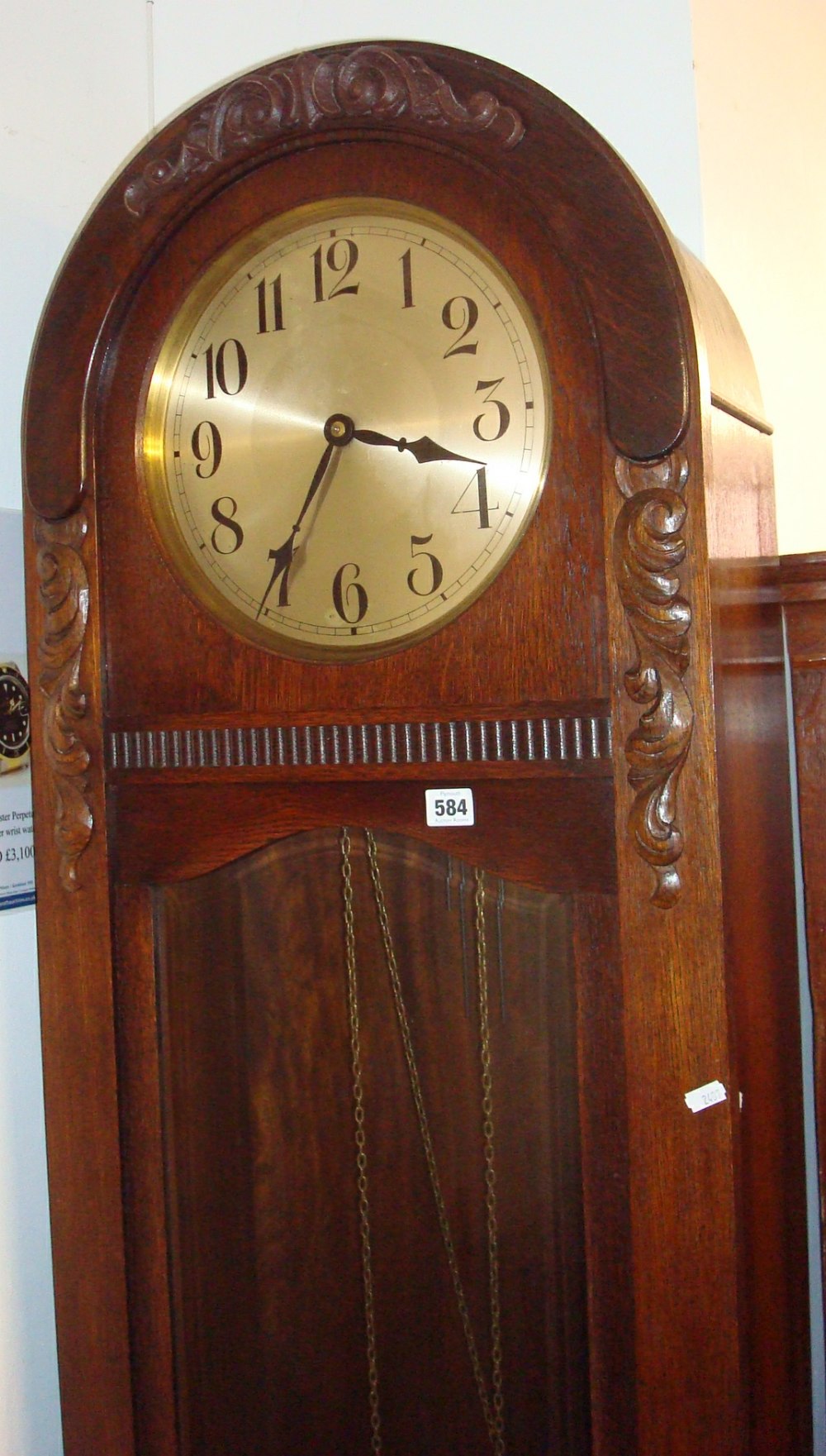 An oak cased grand mother clock, circa 1930, with three train chiming movement (with brass cased