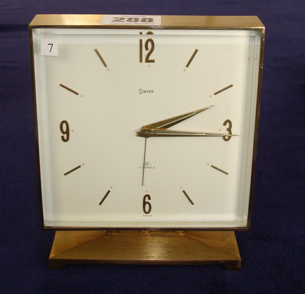 Swiza 8 day brass cased clock with alarm of `Deco` influence having a square case on a plinth base