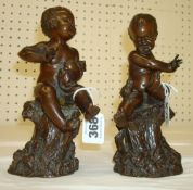 Pair of bronze effect figures depicting a child with a cat and a distressed child with a frog in