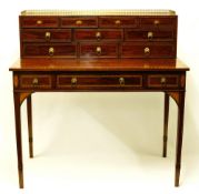 An early 19th century mahogany desk having an upper section with three quarter arcade gallery over a