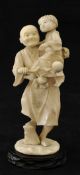 Carved Japanese ivory figure, Man With Child on stand, 14cm