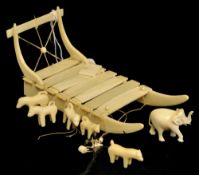 An Inuit carving ivory of a sleigh driven by huskies, 16cm long, also a small carved elephant (