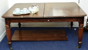 Early Victorian Mahogany dining table with pull out mechanism and fluted legs on brass castors,