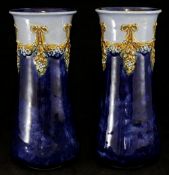 Pair of Doulton pottery vases decorated with swags of vines on blue ground 24cm
