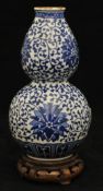 A small 19th century Chinese blue and white double gourd vase, 17cm and later stand t/w with two