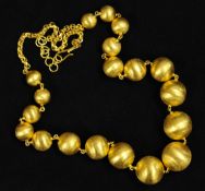 A Middle Eastern gold bead necklace, 45cm long, stamped 21K, approx 62.80g