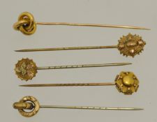 Five yellow metal stick pins