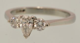 A diamond ring set with central pear cut diamond and two round cut diamonds in white gold, size K