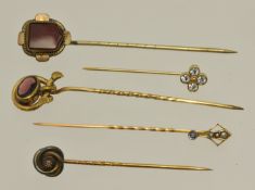 Five yellow metal stick pins including diamond