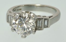 A fine single stone Diamond Ring with Diamond Shoulders set in platinum, with recent insurance