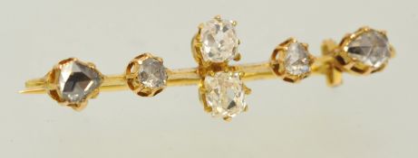 A diamond bar brooch, set with two old cushion cut diamonds and four rose cut faceted diamonds