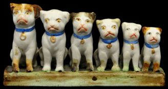 Small porcelain model of six graduated pug dogs 4cm wide
