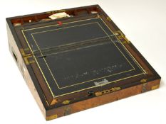 A Victorian walnut and brass bound `campaign` writing slope, the interior fitted with two inkwell,