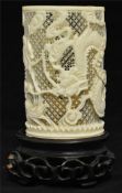 Chinese carved and reticulated ivory brush holder decorated with dragon 9cm long on carved wood
