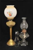 A brass oil lamp with Corinthian style column, together with an all glass oil lamp and shade (2)