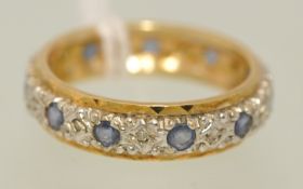 A full band keepers ring, unhallmarked, size, N, t/w 18ct gold ring set with seven modern round
