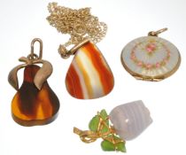 Four items of jewellery including two silver pendants, one enamel locket and one gold mounted `