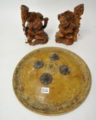 Pair of Chinese carved wood figure candlesticks, 25cm and a circular old leather shield (3).