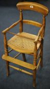 Late Victorian child`s high chair with cane seat, turned legs and bar back, 85cm high.