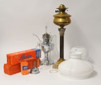 Old brass oil lamp with Corinthian column, chrome Aladdin oil lamp and two old leather suitcases (